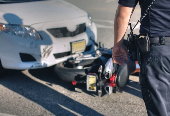 Motorcycle accident attorney documenting an injured rider at a motorcycle crash site