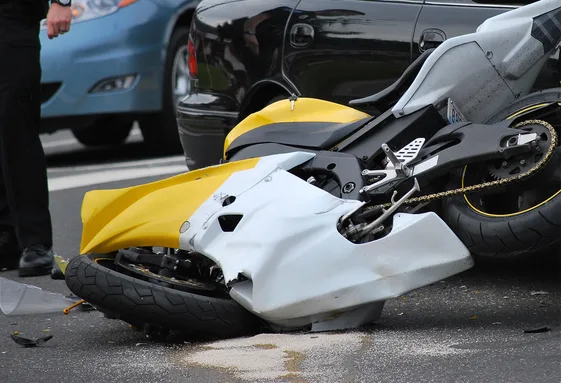 Motorcycle accident lawyer at a collision scene with an injured rider needing legal help